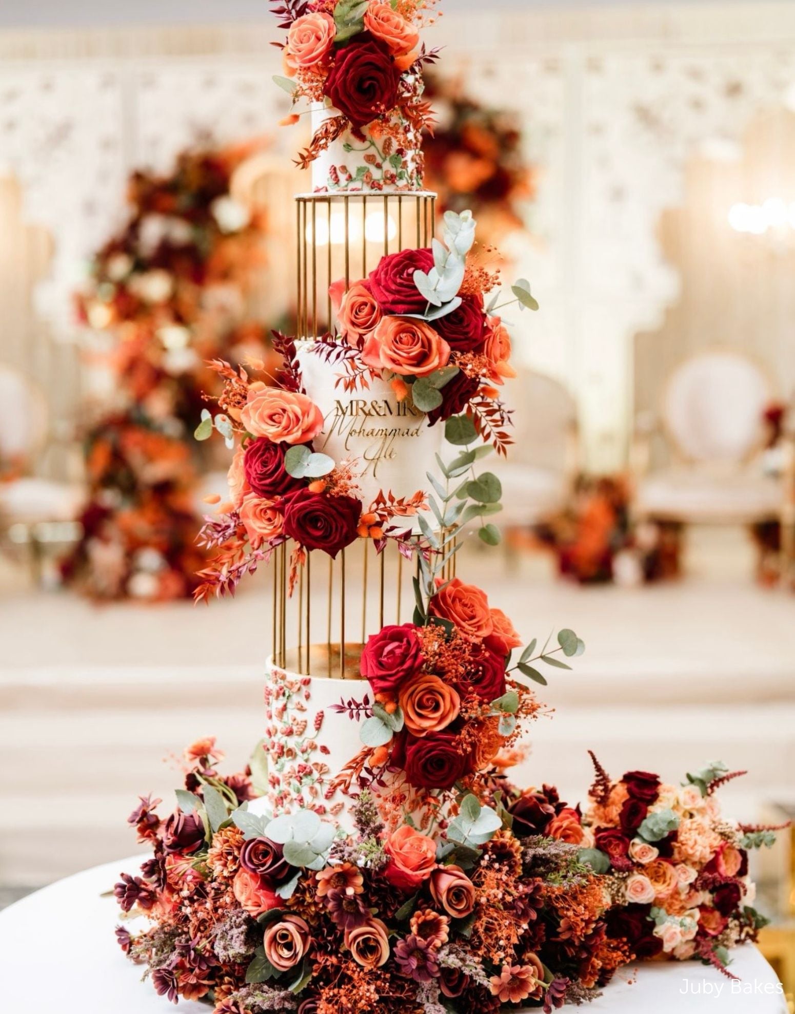 Gold birdcage metal cake separators used in a tall floral wedding cake display by Prop Options