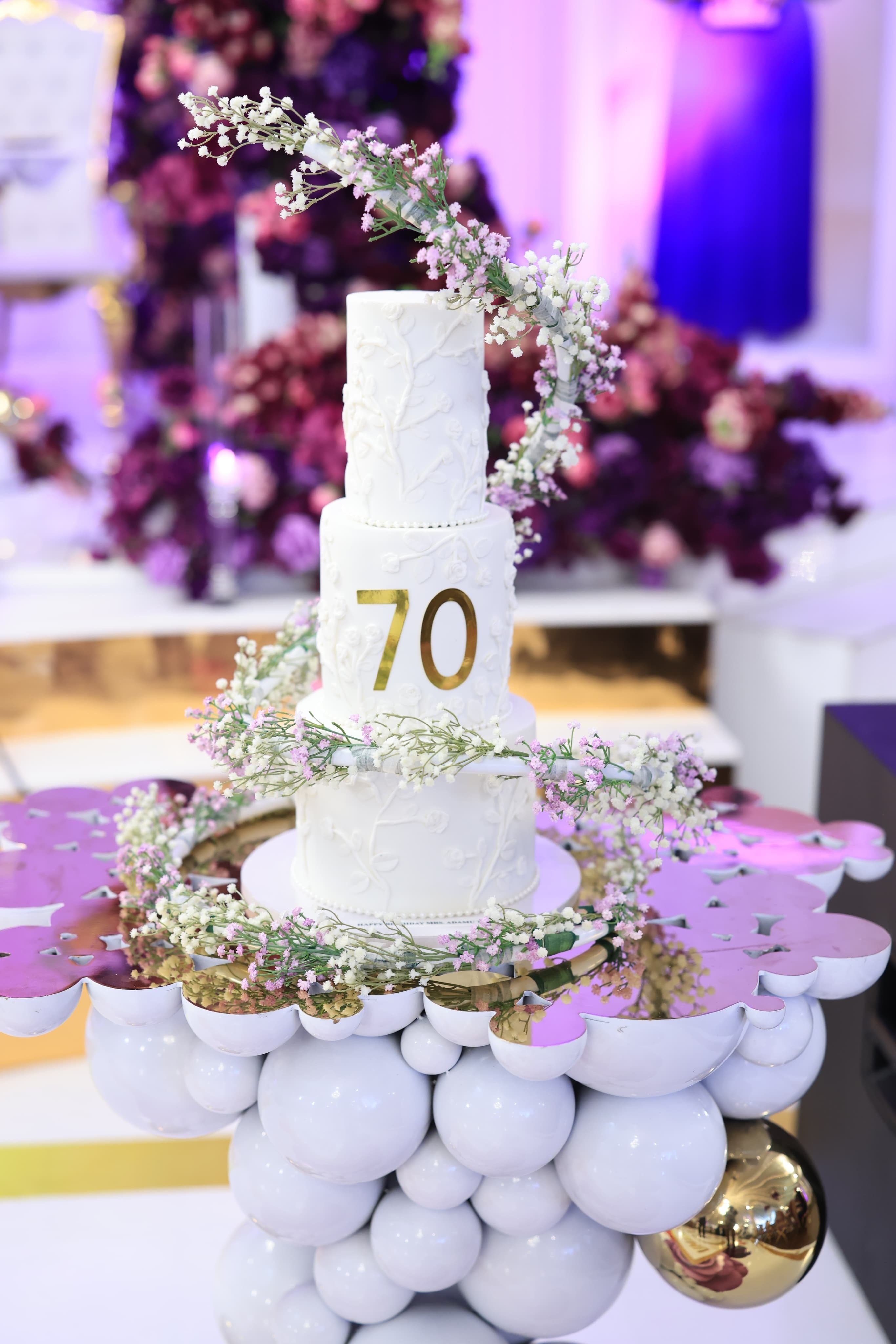 Cake Spiral - Metal Wrap, white plastic-coated metal spiral wound around a four tier white wedding cake with floral detail